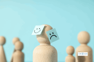 Wooden figure with happy and sad face notes on head, symbolizing bipolar disorder treatment at Empower Health Group
