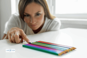 Woman arranging colored pencils in order on desk, symbolizing obsessive compulsive disorder treatment at Empower Health Group