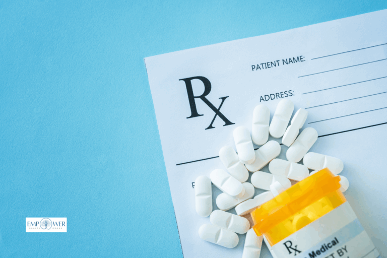 Prescription pills spilling from orange bottle onto prescription pad, representing prescription drug addiction treatment at Empower Health Group