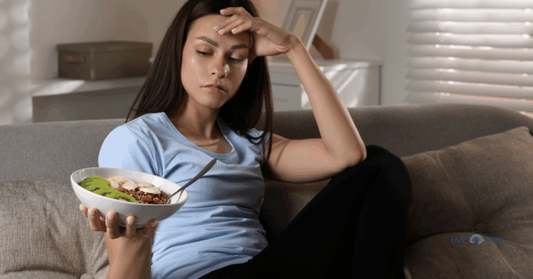 Young woman sitting on couch looking at bowl of food, symbolizing pica treatment and eating disorder recovery at Empower Health Group