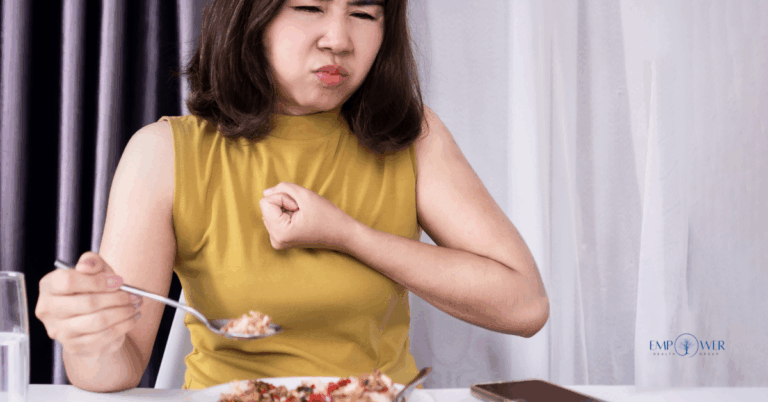 Woman struggling while eating, symbolizing rumination disorder treatment and recovery at Empower Health Group